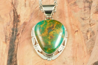 Genuine Royston Turquoise set in Sterling Silver Pendant. Beautiful Turquoise Stone. Created by Navajo Artist Phillip Sanchez. Signed by the artist. Royston Turquoise Mine was originally known as the Royal Blue Mine. It produces Turquoise that has a mixture of blues and greens in the same formation. The Royston Turquoise Mine is located in Nye County, Nevada. Free 18 inch Sterling Silver Chain with purchase of pendant.